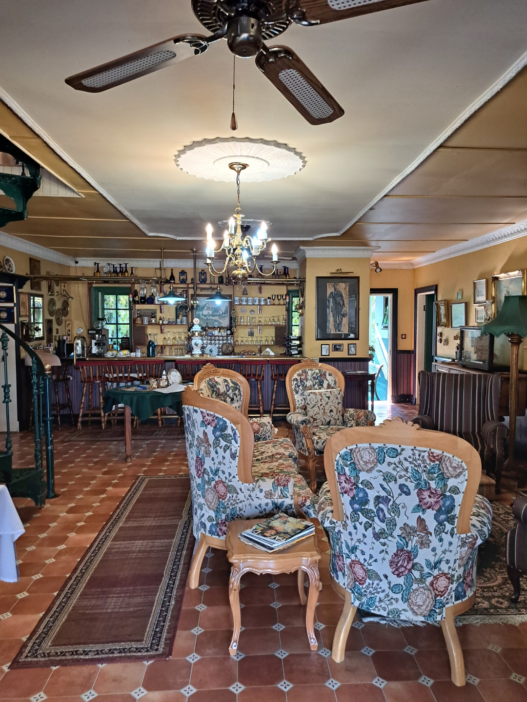 Victorian lounge with antique furniture, ceiling fan, and chandelier