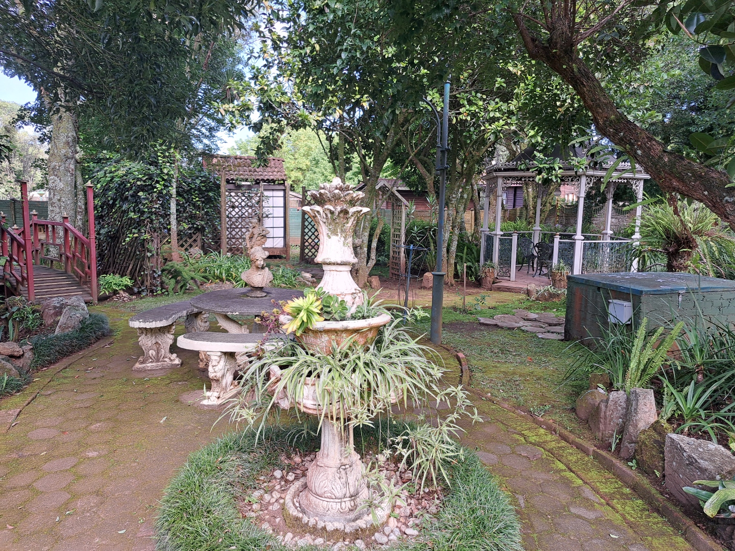 Lush garden with fountain, gazebo, and tropical plants