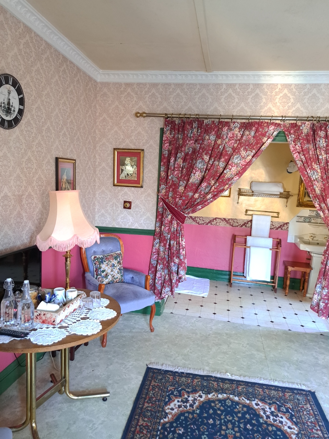 Deluxe Red Room — sitting area with lamp and clock