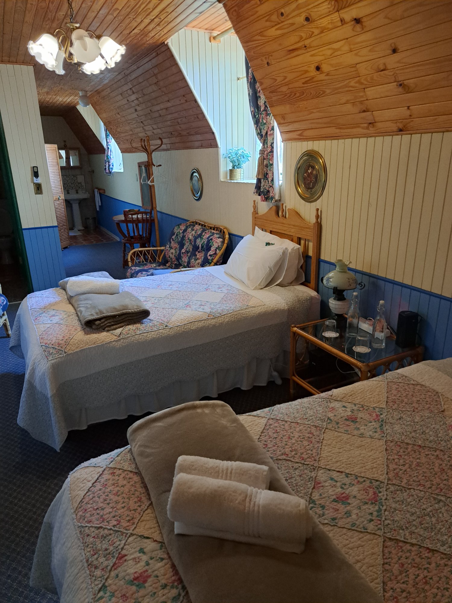 Twin Room — close view of beds with rattan furniture and en-suite